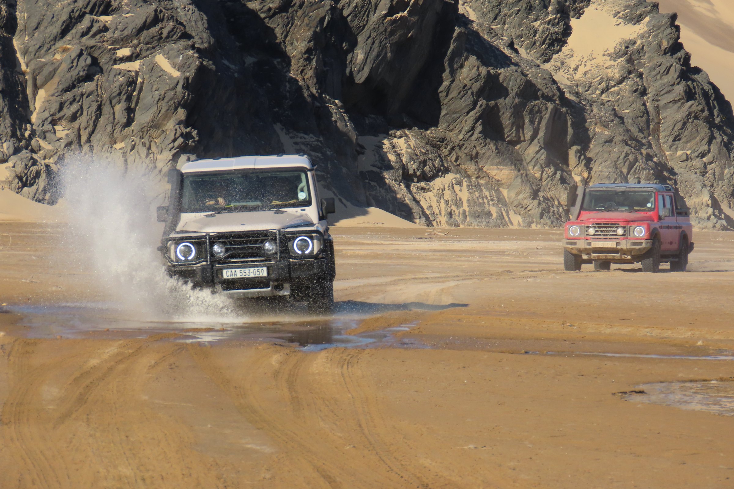 4x4 expedition vehicles crossing a rocky pass in Kaokoland